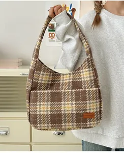 Close-up of vintage plaid tote bag featuring a front pocket and leather fashion label
