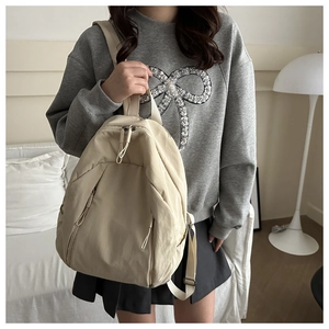 Lifestyle shot of a cream-colored large capacity laptop backpack in a cozy home setting