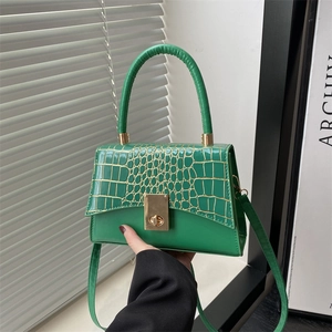 Sac à main élégant vert émeraude avec texture crocodile dorée et boucle métallique