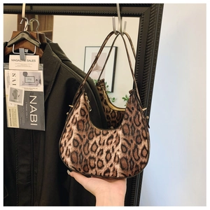 Detail of leopard print hobo bag showing the half-moon shape and golden side rivets