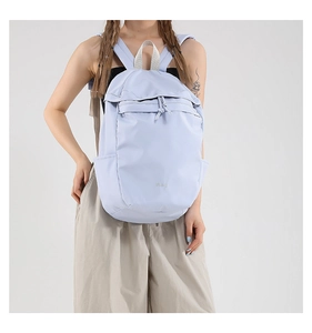 Close-up of a lilac nylon backpack featuring a front zipper pocket and adjustable straps