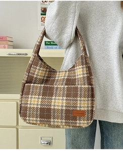 Close-up of vintage plaid tote bag with luxury wool texture and leather brand label