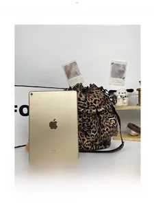 Leopard print bucket bag shown next to a tablet to demonstrate large storage capacity