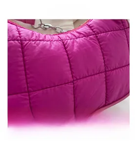 Détail du sac bandoulière matelassé rose vif avec chaîne argentée et texture bouffante