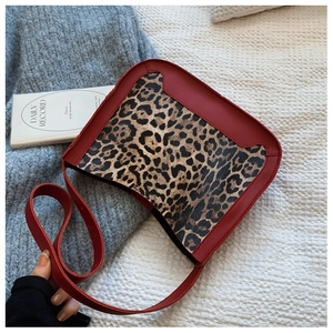 Detailed overhead shot of leopard print shoulder bag with dark red leather trim accents