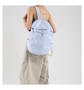 Detail of light purple nylon backpack with drawstring closure worn by a fashion model