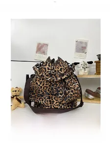 Detailed close-up of a leopard print bucket bag featuring a drawstring closure and nylon strap