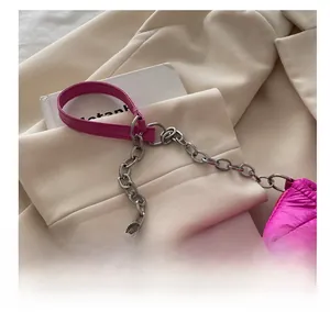 Gros plan d'un sac à bandoulière matelassé rose avec chaîne argentée et losanges