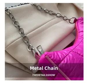 Détail du sac fuchsia matelassé montrant la chaîne argentée et le tissu en nylon résistant