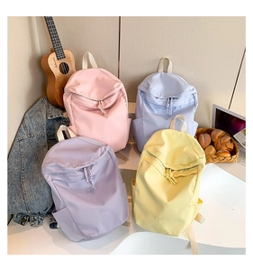 Close-up of lightweight nylon backpacks in pastel pink, blue, purple, and yellow colors
