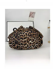 Detailed bottom view of leopard print crossbody bucket bag with curved base