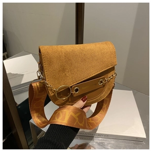 Détail du sac selle vintage en daim avec large bandoulière à motifs et gravure