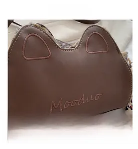 Détail des oreilles de chat et broderie Mooduo sur le sac à bandoulière en cuir PU brun