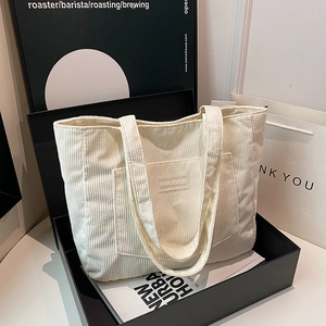 Minimalist white corduroy tote bag with dual shoulder straps and spacious design