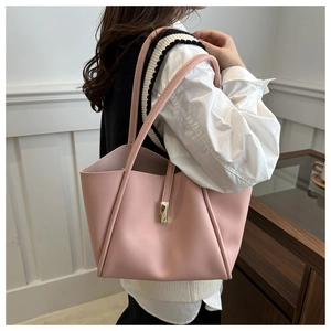 Dettaglio di una borsa tote rosa in ecopelle con fibbia dorata e tracolla