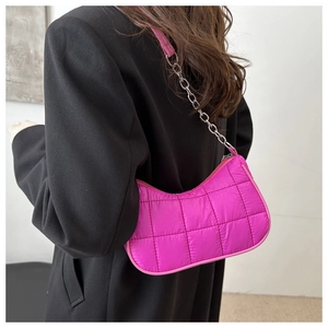 Gros plan du sac à bandoulière matelassé rose vif avec chaîne en métal et sangle en tissu