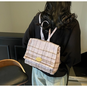 Détail du sac à dos en laine à carreaux lavande avec logo métallique doré élégant