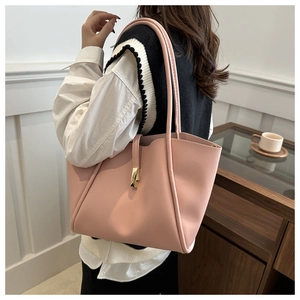 Borsa tote rosa in pelle con fibbia dorata indossata sulla spalla in ambiente lifestyle