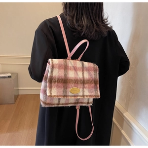 Détail d'un sac à dos d'hiver en laine à carreaux avec tissu en peluche rose et fermoir doré