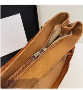 Détail de la fermeture éclair en métal et de la texture en toile du sac fourre-tout brun