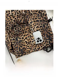 Detail of leopard print tote featuring a large front pocket for smartphones and drawstring