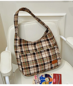 Close-up of retro plaid pattern fabric and leather label on large tote shoulder bag