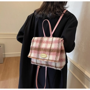 Sac à dos à carreaux rose et blanc en laine porté par un mannequin en hiver