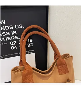 Détails d'un sac cabas en toile caramel avec poignées renforcées et fermeture éclair
