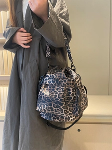 Detail of leopard print bucket bag featuring a drawstring closure and a thick stylish strap