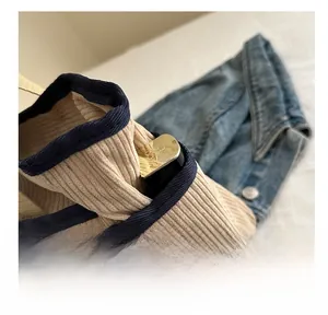 Détail de la poche latérale d'un sac cabas en velours côtelé pour petits accessoires