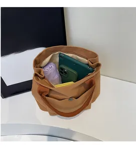 Vue macro du sac fourre-tout en toile kaki montrant le compartiment intérieur spacieux zippé