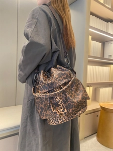 Detail of vintage leopard print bucket bag with drawstring closure and black hardware