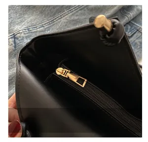 Close-up of the black leather tote interior showing the smooth golden metal zipper detail