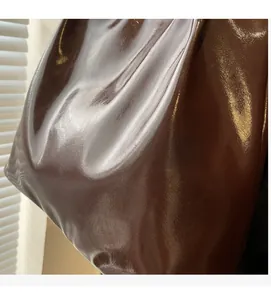 Close-up of soft glossy coffee brown leather texture on a vintage tote bag