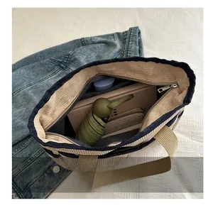 Vue intérieure montrant la grande capacité du sac cabas en velours beige avec liseré bleu