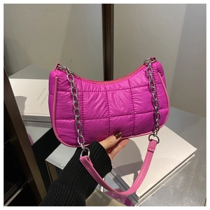 Détail d'un sac à bandoulière matelassé rose vif avec chaîne argentée et tissu en nylon