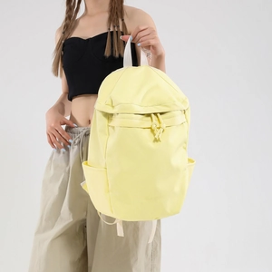 Light yellow nylon backpack with white straps and BAG embossed logo detail