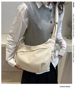 Détail de la texture du sac bandoulière en velours côtelé beige et forme croissant