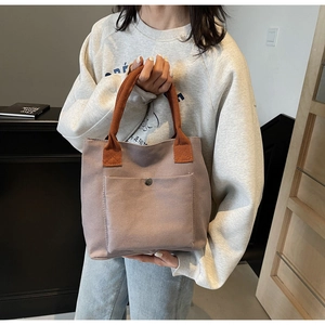 Détail du sac fourre-tout en toile avec poignées orange et poche à bouton-pression métal