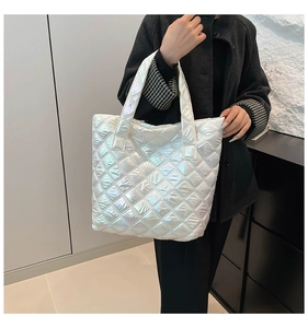 Borsa tote trapuntata iridescente di grande capacità indossata sulla spalla dal modello