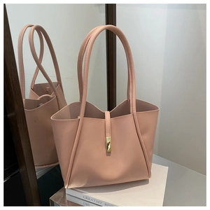 Dettaglio della borsa tote in pelle rosa con doppi manici lunghi e chiusura in metallo oro