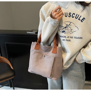 Détail du sac cabas en toile taupe avec poignées orange et poche avant à pression
