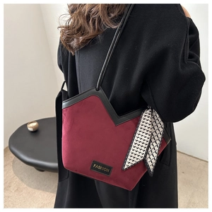 Detail view of burgundy velvet tote bag featuring black piping and decorative silk scarf