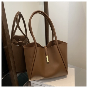 Dettaglio della grande borsa tote in ecopelle marrone con elegante chiusura metallica dorata