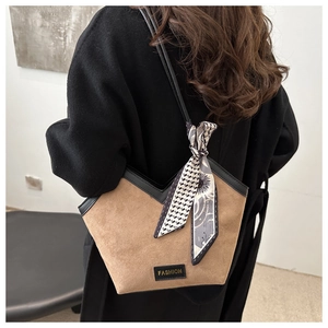 Detail of brown suede tote bag with V-cut edge, silk scarf and Fashion label detail