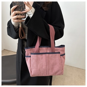 Détail du sac cabas en velours côtelé rose avec texture et bordure bleu marine