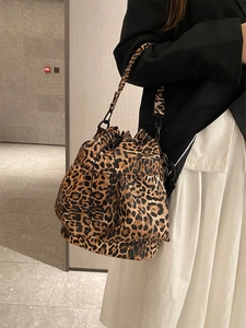 Fashionable leopard print bucket bag with drawstring closure and wide shoulder strap