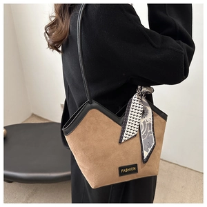 Detail of retro brown suede tote bag with V-shaped opening and decorative silk scarf