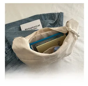Vue intérieure d'un grand sac bandoulière en velours beige avec rangement spacieux