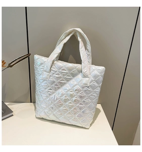 Borsa tote trapuntata bianca iridescente con cuciture geometriche su sfondo minimalista
